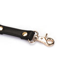 Black vegan leather strap with quick-release gold clip and rivets for bondage hogtie, part of Dark Candy collection