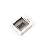 Packaging of black magnetic nipple clamps in a white marble-patterned box with clear display window for BDSM bedroom play