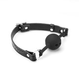 Black silicone ball gag with adjustable faux crocodile leather strap and metal buckles for bondage play