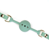 Mint green breathable silicone ball gag with leather straps and glamorous gold metal hardware from the Fairy collection