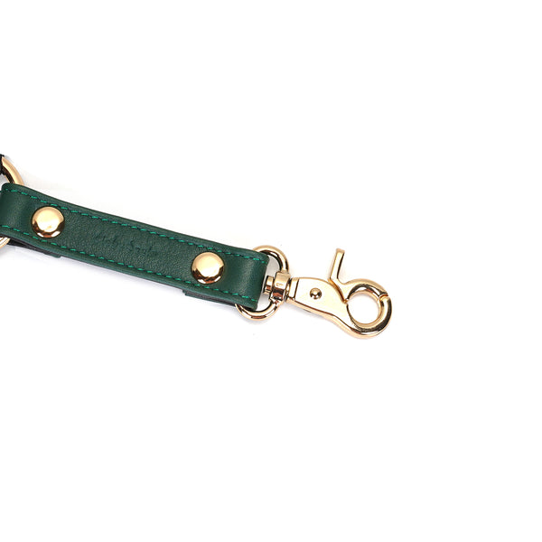 Close-up of Mossy Chic green leather hogtie with gold quick-release clip, luxurious leather bondage gear