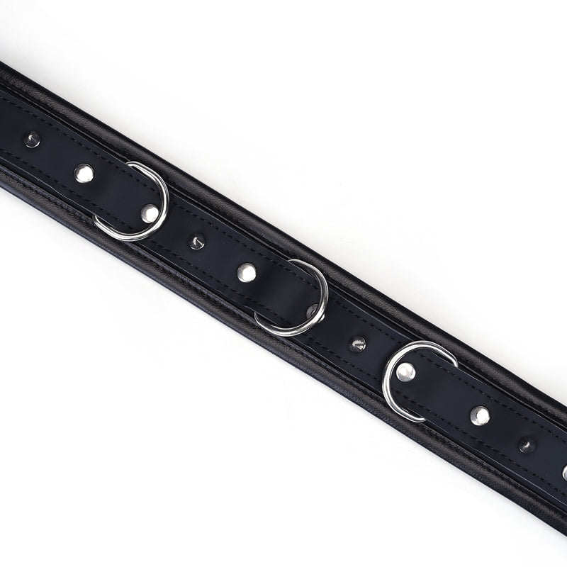 Black vegan leather bondage collar with silver D-rings and studded design for ethical restraint play