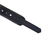 Close-up of black vegan leather studded collar with silver hardware, adjustable holes for BDSM play