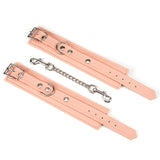 Pink vegan leather handcuffs with silver hardware and connecting chain for BDSM play, part of the Dark Candy collection