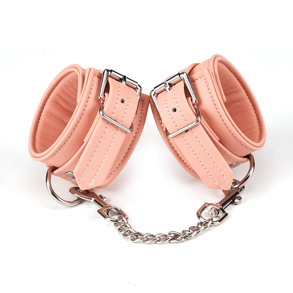 Pink vegan leather handcuffs with silver hardware from the Dark Candy collection, ideal for BDSM and roleplay scenarios