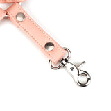 Close-up of a pink vegan leather strap with silver quick-release clip, part of Dark Candy bondage gear