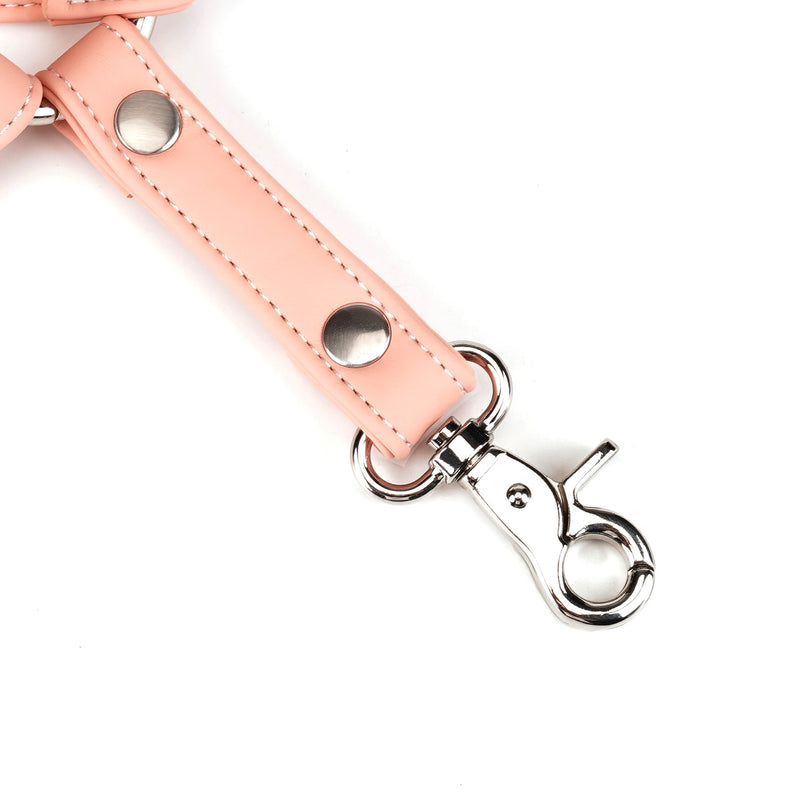 Close-up of a pink vegan leather strap with silver quick-release clip, part of Dark Candy bondage gear