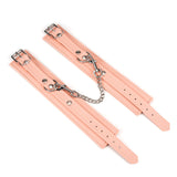 Pink vegan leather ankle cuffs with silver hardware from Dark Candy collection, featuring adjustable straps and durable chain link for BDSM play