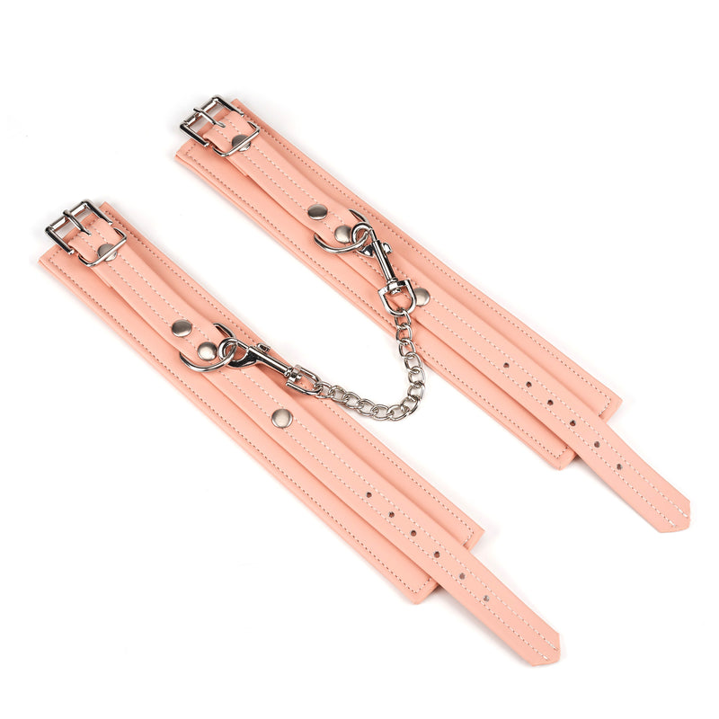 Pink vegan leather ankle cuffs with silver hardware from Dark Candy collection, featuring adjustable straps and durable chain link for BDSM play