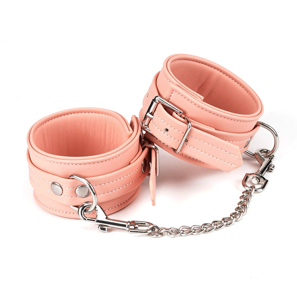 Pink vegan leather ankle cuffs with silver hardware and chain from the Dark Candy collection, ideal for BDSM play