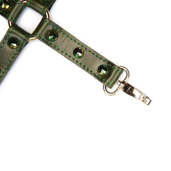 Close-up of luxury green leather hogtie with gemstones and gold-colored metal clips, designed for erotic bondage play
