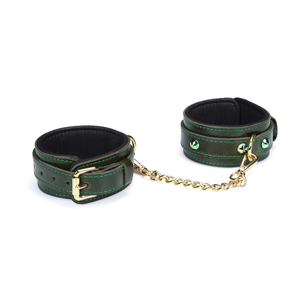 Luxury green leather wrist cuffs with gemstones and gold chain linkage, adjustable straps for secure bondage play