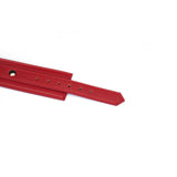 Red faux leather adjustable wrist cuffs for bondage, detail view showing buckle holes and vibrant color