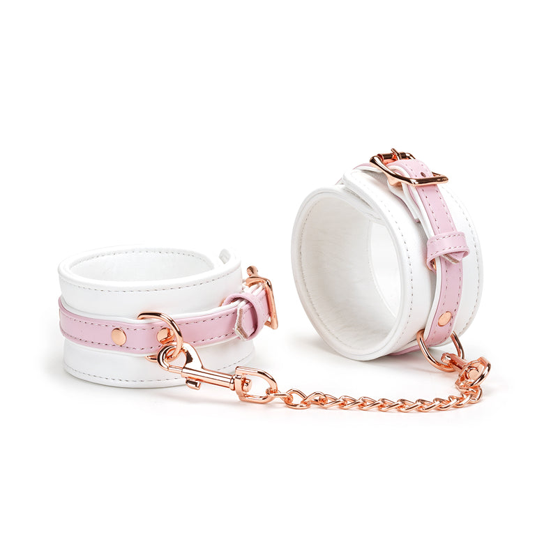 White and pink leather ankle cuffs with rose gold hardware from the Fairy collection, demonstrating premium design and adjustable features for BDSM play
