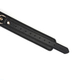 Black leather thigh cuff from Dark Secret collection with gold hardware and adjustment holes, perfect for bondage play