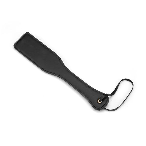 Black vegan leather spanking paddle from Dark Candy collection, perfect for BDSM beginners, featuring a durable wrist loop for secure handling