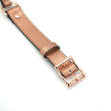 Rose gold leather strap with polished buckle for bondage ball gag, highlighting luxury and restraint in BDSM play
