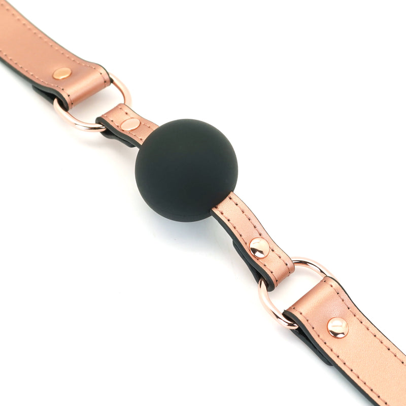 Rose gold leather strap silicone ball gag with matte black ball and metal buckles, part of the Rose Gold Memory bondage collection