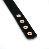 Close-up of black leather strap with rose gold eyelets from Rose Gold Memory leather bondage collection