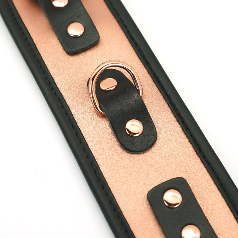 Close-up of rose gold leather handcuff with black trim, metallic rivets, and buckle from Liebe Seele's BDSM wrist restraints collection