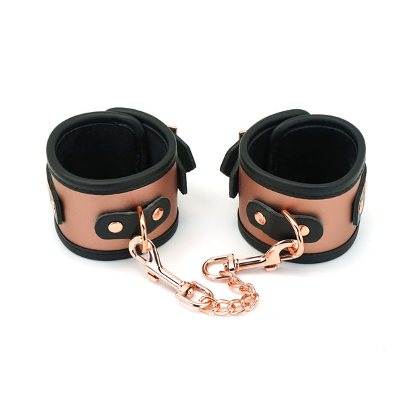 Rose gold leather handcuffs with faux fur lining connected by a rose gold chain, ideal for BDSM wrist restraints