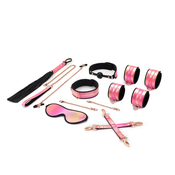 Vivid Sakura glossy pink soft bondage kit with flogger, ball gag, cuffs, collar and leash, blindfold, and nipple clamps on white background