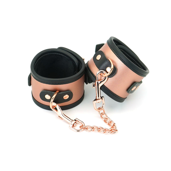 Rose gold leather BDSM ankle cuffs with faux fur lining and detachable link chain for bondage play