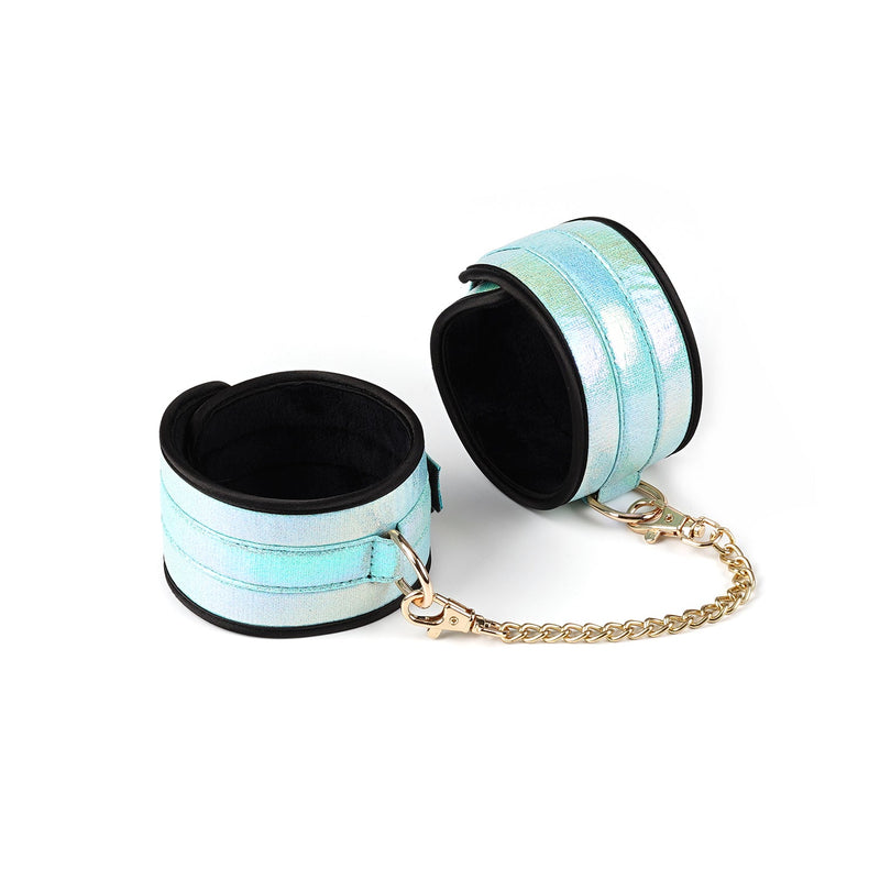Glossy blue wrist cuffs from Vivid Sorairo soft bondage kit with gold chain and holographic finish