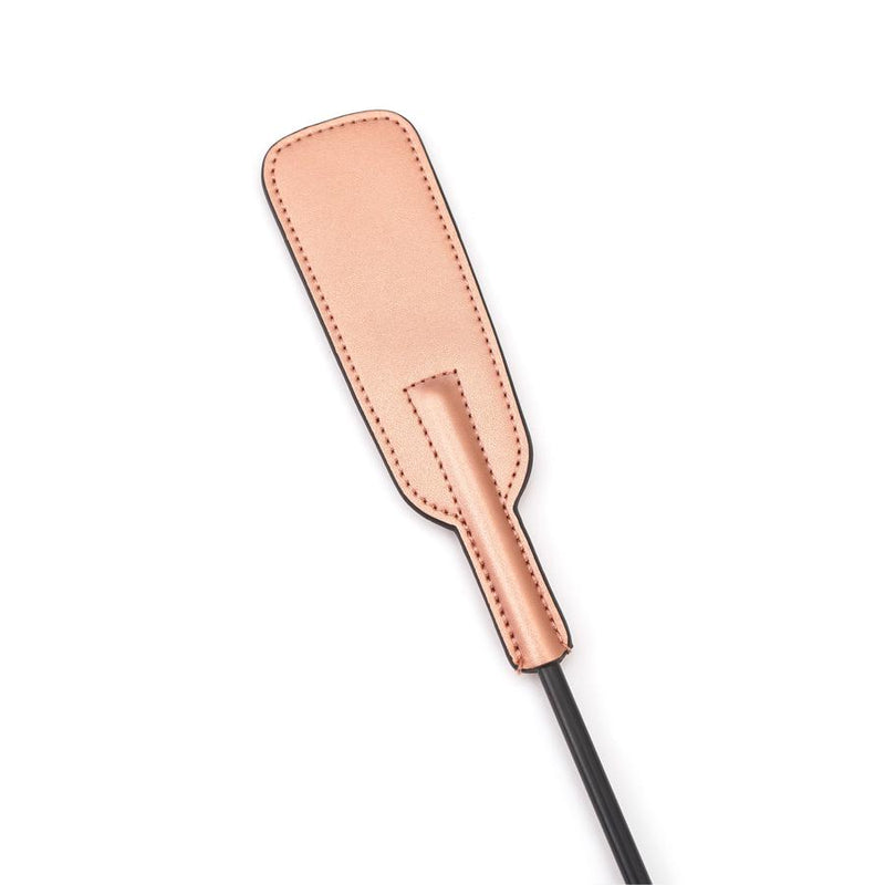 Rose gold leather spanking crop with black handle for BDSM impact play, ideal for experienced and novice users alike