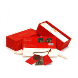 Luxury packaging of LIEBE SEELE Equestrian Leather Ankle Cuffs with vintage gold hardware, featuring the product in a detailed red box, accompanying tags, and a fabric pouch