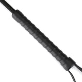 Close-up of vegan leather riding crop with textured handle and wrist loop for BDSM play.