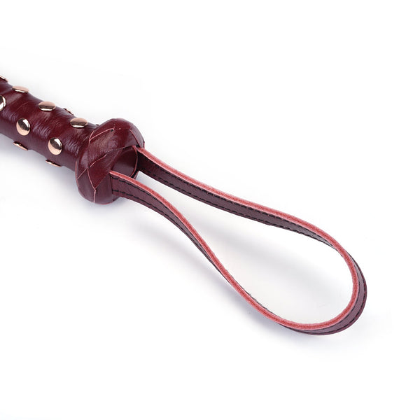 Wine red heavy leather flogger with studded handle for BDSM play, featuring a sturdy wrist loop