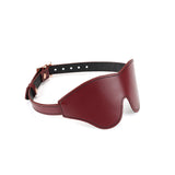 Luxurious wine red leather blindfold with rose gold buckle, adjustable strap, designed for erotic sensory deprivation in the Wine Red collection