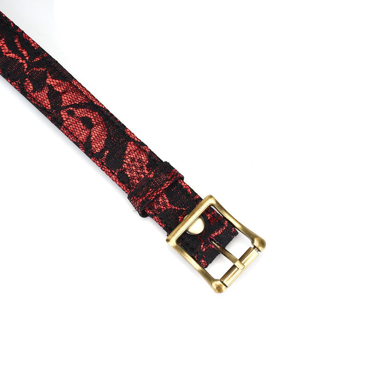 Close-up of Victorian Garden bondage ball gag strap with black lace over red fabric and brass buckle