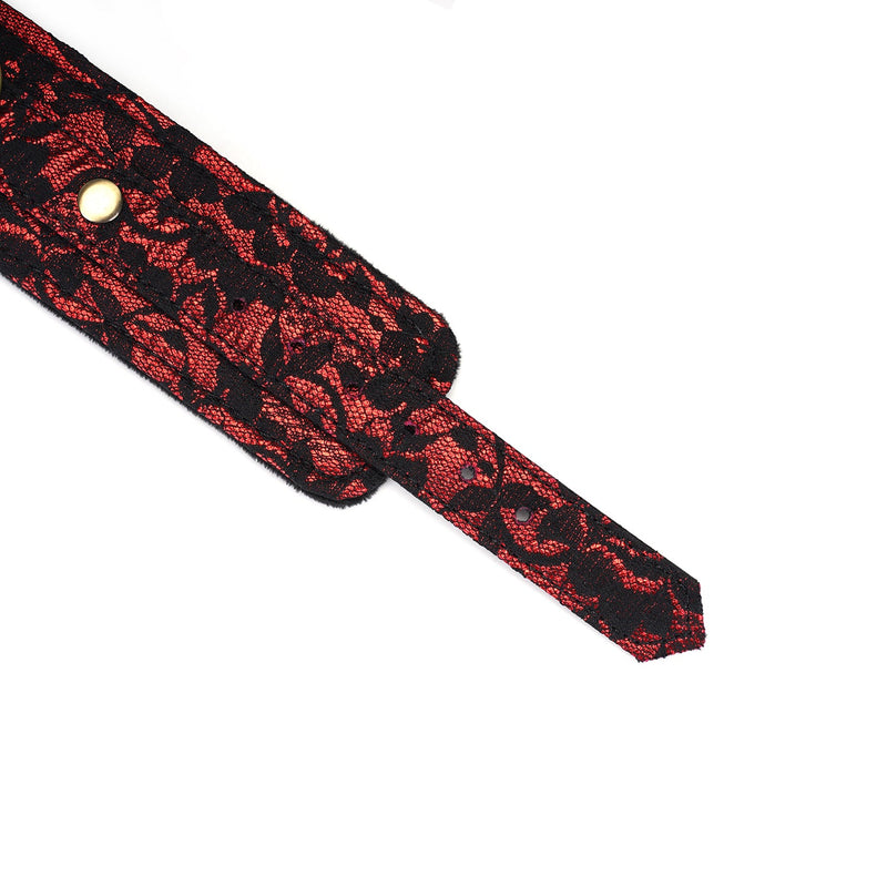 Close-up of Victorian Garden lace and vegan leather handcuff with brass snap, showcasing intricate red and black design for BDSM play