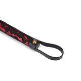 Red and black lace-covered handle of Victorian Garden vegan leather flogger with brass metal detail