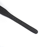 Close-up view of black leather collar strap with adjustment holes and ostrich skin texture for BDSM wear