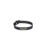 Black leather 'Slut' choker with ostrich skin pattern from the Angel's & Demon's Kiss Bondage collection, showcasing golden letters and adjustable buckle.