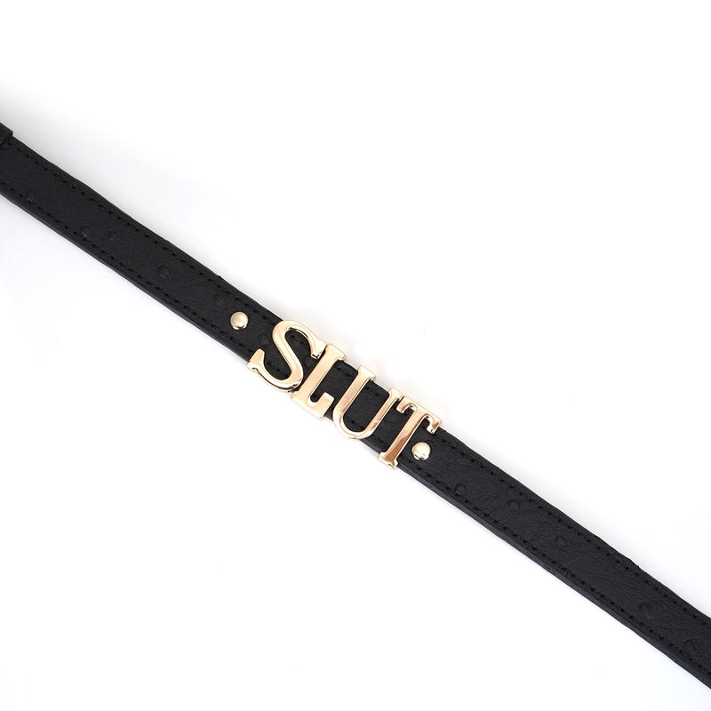 Black leather bondage collar with gold 'SLUT' lettering, ostrich skin pattern, and adjustable buckle holes from the Angel's & Demon's Kiss collection