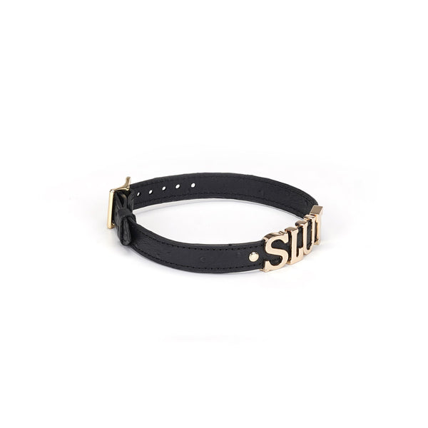 Black leather bondage collar with 'SLUT' in silver letters and gold accents from the Angel's & Demon's Kiss collection