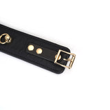 Black leather ankle cuff with gold buckle and ostrich skin pattern for BDSM play