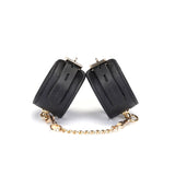 Black leather handcuffs with ostrich skin pattern and gold hardware from the Angel's & Demon's Kiss Bondage collection