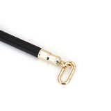Close-up of Black Leather-Coated Spreader Bar with Gold-Toned Quick-Release Clip on Ostrich Skin Pattern