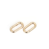 Golden quick-release clips for BDSM restraints, compatible with luxury bondage gear like the Demon's Kiss Black Leather-Coated Spreader Bar