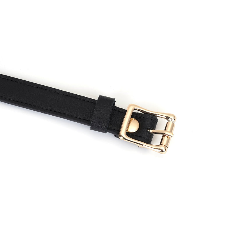 Close-up of black leather blindfold strap with gold buckle for bondage play, part of the Dark Secret BDSM collection