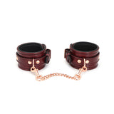 Wine red leather ankle cuffs with rose gold hardware, part of the LIEBE SEELE bondage collection