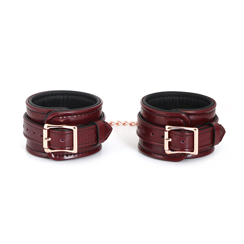 Luxurious wine red leather ankle cuffs with rose gold hardware, adjustable for bondage play