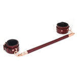Wine Red leather spreader bar with rose gold accents for BDSM play, featuring adjustable ankle cuffs.