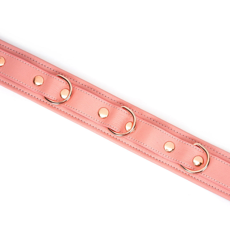 Close-up view of Pink Dream leather bondage collar with rose gold hardware and glossy studs, perfect for BDSM play