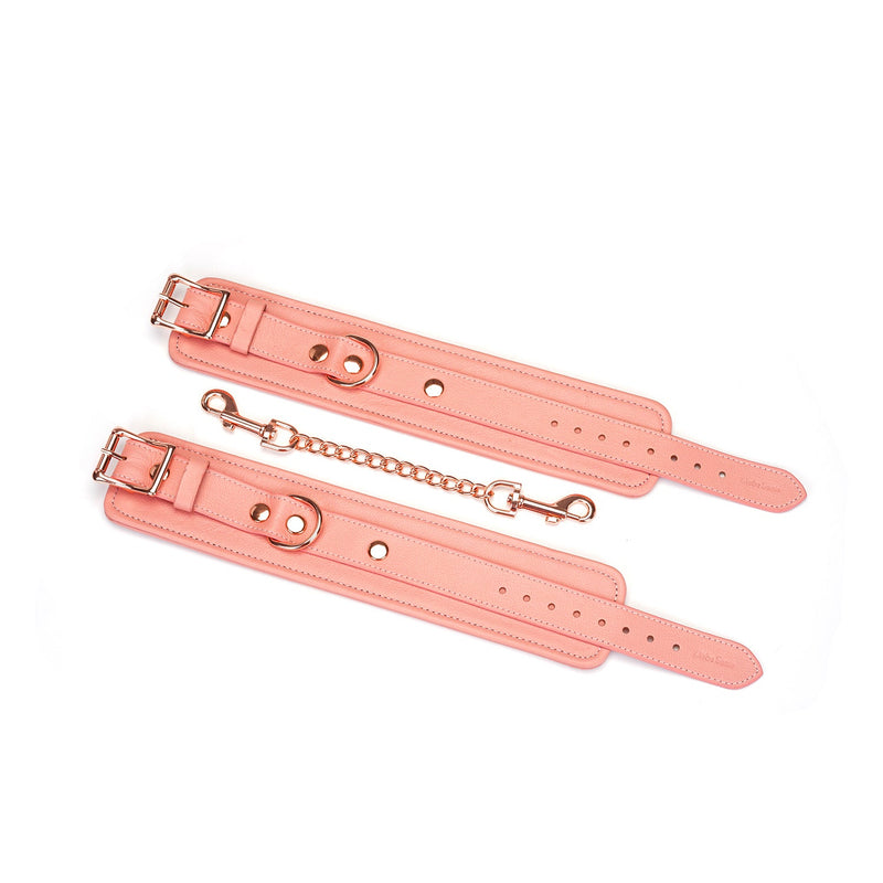 Pink leather bondage ankle cuffs with rose gold hardware and connecting chain from the Pink Dream collection